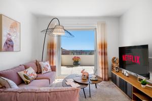 a living room with a couch and a tv at Le Coq Elysium - Exceptional 220 sqm Penthouse - Private Terrace & Jacuzzi - AC - 3 Parking Spaces in Menton