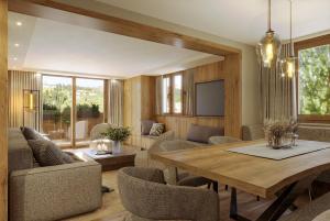 a living room with a wooden table and chairs at Edelweiss Apartments in Lech am Arlberg