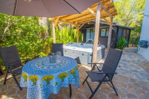 a patio with a table and chairs and a tub at Casa Les Fremeaux in Altea