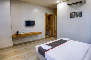 a bedroom with a bed and a tv on the wall at Shubhham Regency in kolkata