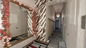 ein Flur mit einem Spiegel und Blumen an der Wand in der Unterkunft Siena Hotel in Odessa