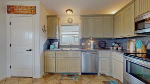 a kitchen with white cabinets and a sink at Casa Siwichi home in Crystal Beach
