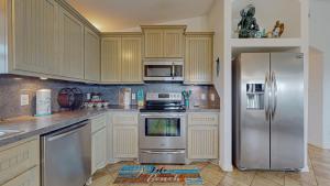 a kitchen with stainless steel appliances and wooden cabinets at Casa Siwichi home in Crystal Beach +20 photos