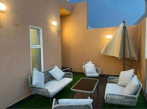 a patio with two chairs and a table and an umbrella at فلل اسوار الوسام الفندقية in Taif