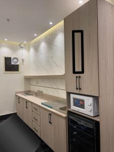 a kitchen with a stove and a microwave at فلل اسوار الوسام الفندقية in Taif