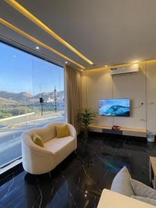 a living room with a couch and a flat screen tv at فلل اسوار الوسام الفندقية in Taif