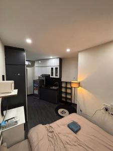 a hotel room with a bed and a kitchen at Amoureux Cầu Diễn in Tây Tựu