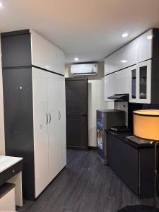 a kitchen with white cabinets and a black refrigerator at Amoureux Cầu Diễn in Tây Tựu +49 photos