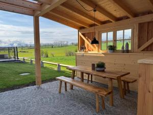 a wooden pavilion with a wooden table and benches at Winkelfeldhof in Eglfing