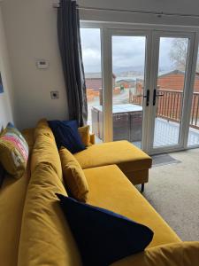 a living room with two yellow couches and a balcony at V+B Hygge in Windermere