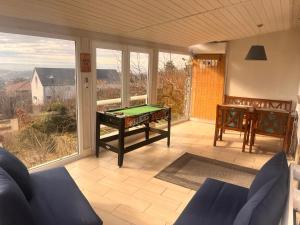 a screened in porch with a pool table and a balcony at Bálics Vendégház in Pécs