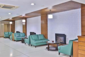 a waiting room with blue chairs and a fireplace at Avari Xpress Gulberg in Lahore