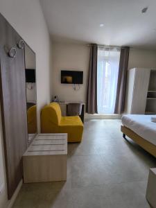 a bedroom with a yellow chair and a mirror at Hotel Domus Rome in Rome