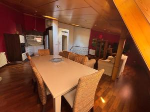 a dining room with a white table and chairs at Dúplex centro de Ribeira con WIFI by Cristian&Tamara"alquileres" in Ribeira