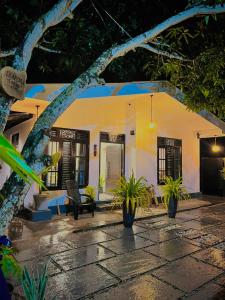 a yellow and white house with plants in front of it at LEAFORA Cottage in Galle