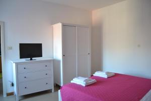 a bedroom with a bed and a dresser with a tv at Casa Valentina in Brenzone sul Garda