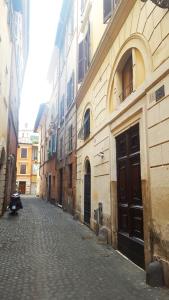 ローマにあるナヴォーナ スタジオ アパートメントの石畳の通りを持つ古い建物内の路地