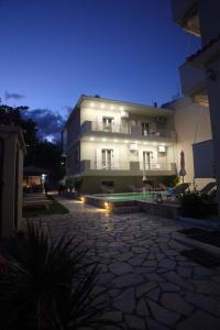 a large building at night with a stone courtyard at Aggelina in Nydri