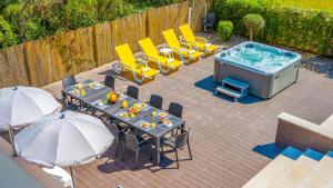 a patio with a table and chairs and a hot tub at Villa Bahamas - Jacuzzi e piscina aquecível em Armação de Pêra in Armação de Pêra