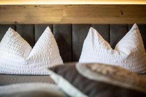 two white pillows are sitting on a bed at Hotel Arcobaleno in Fai della Paganella