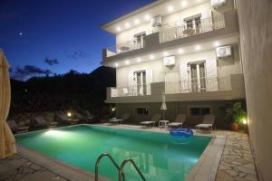a hotel with a swimming pool in front of a building at Aggelina in Nydri