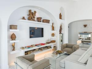 a living room with white furniture and a tv at Grand Hotel Europa Palace Sorrento in Sorrento