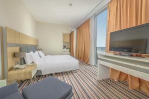 a hotel room with a bed and a flat screen tv at Radisson Blu Hotel Batumi in Batumi