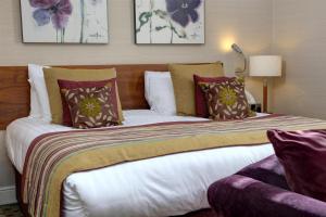a bedroom with a large bed with pillows at The Bull Hotel; Sure Hotel Collection by Best Western in Peterborough