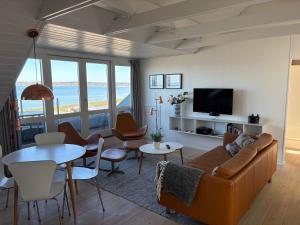 a living room with a couch and a table at Vigen ferielejligheder in Ebeltoft