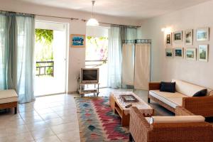 a living room with a couch and a tv at Villa Bienvenue Apartments in Kanapitsa