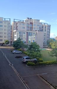 a parking lot with cars parked in front of a building at HM Royal Homes in Nairobi