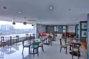 a restaurant with tables and chairs and a large window at Avari Xpress Gulberg in Lahore