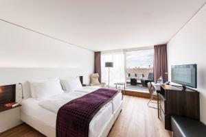 a hotel room with a bed and a flat screen tv at Bergheim 41 Hotel im Alten Hallenbad in Heidelberg