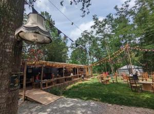 a tent in a yard with a tree at Roulotte enchantée in Cornillé-les-Caves