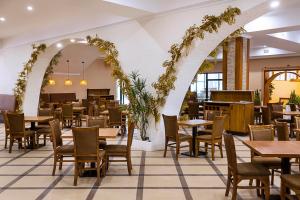 a restaurant with tables and chairs and an archway at Sawela Lodges in Naivasha