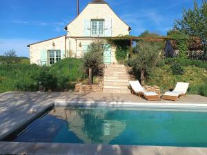 a house with a swimming pool in front of a house at Les Volets Verts-Dordogne in Plazac