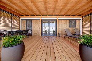 a wooden deck with chairs and tables on it at Mobile Homes Camping Plitvice in Smoljanac +53 photos