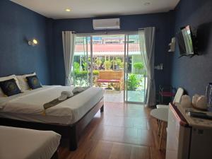 a bedroom with two beds and a door to a patio at Near the Beach Cha-Am in Cha Am