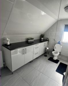 a white bathroom with a toilet and a window at The Pilgrims Cove in Burnham on Sea +18 photos