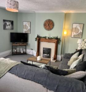 a living room with a couch and a fireplace at The Pilgrims Cove in Burnham on Sea