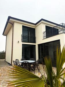 a house with a table and chairs in front of it at Vila CampoAmor Pasohlávky in Pasohlávky