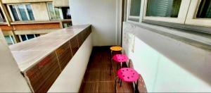 a balcony with two pink benches in a building at Centar S in Pirot