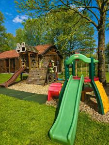 a playground with a slide in a yard at Cicha Dolina in Wydminy
