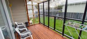 a screened in porch with two chairs and a table at Charisma Homestay in Invercargill +6 photos
