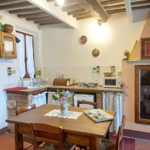 a kitchen with a wooden table and a dining room at House with stunning views in Chiusdino +31 photos