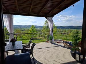 a patio with a table and chairs and a view at Cuibul de pe Deal Coșdeni Bihor in Coşdeni