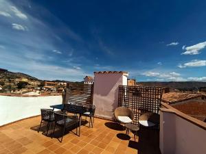 a patio with chairs and a table on a balcony at Apartamentos Casa Memé in Mora de Rubielos
