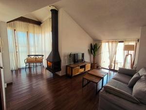 a living room with a couch and a wood stove at Apartamentos Casa Memé in Mora de Rubielos