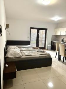 a bedroom with a large bed and a kitchen at Vila Lexus in Veľký Meder
