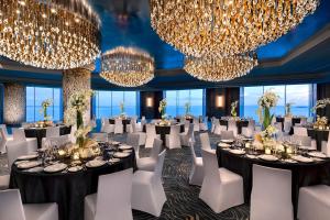 ein Ballsaal mit Tischen, Stühlen und Kronleuchtern in der Unterkunft NUSTAR Hotel Cebu in Cebu City + 35 Fotos